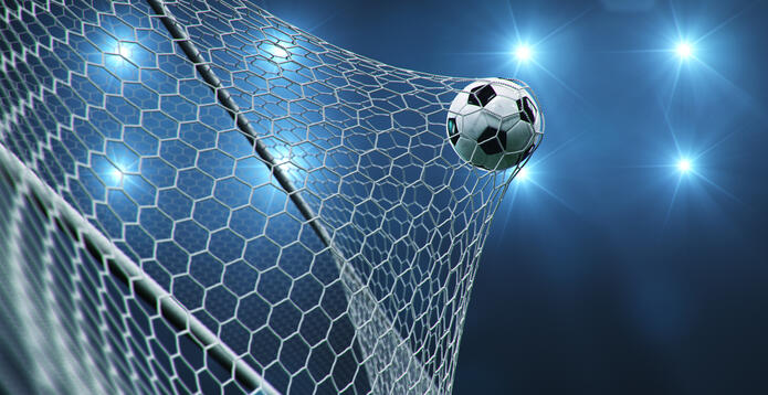 A football flying into a goal net against a blue background