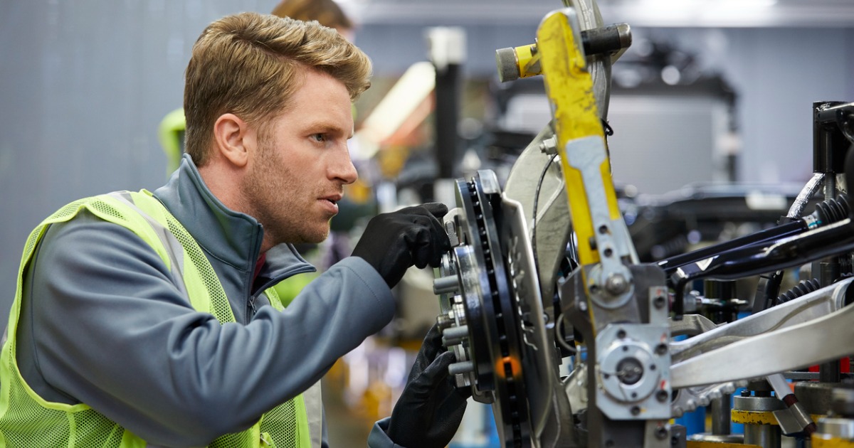 confident-male-engineer-examining-car-chassis seo