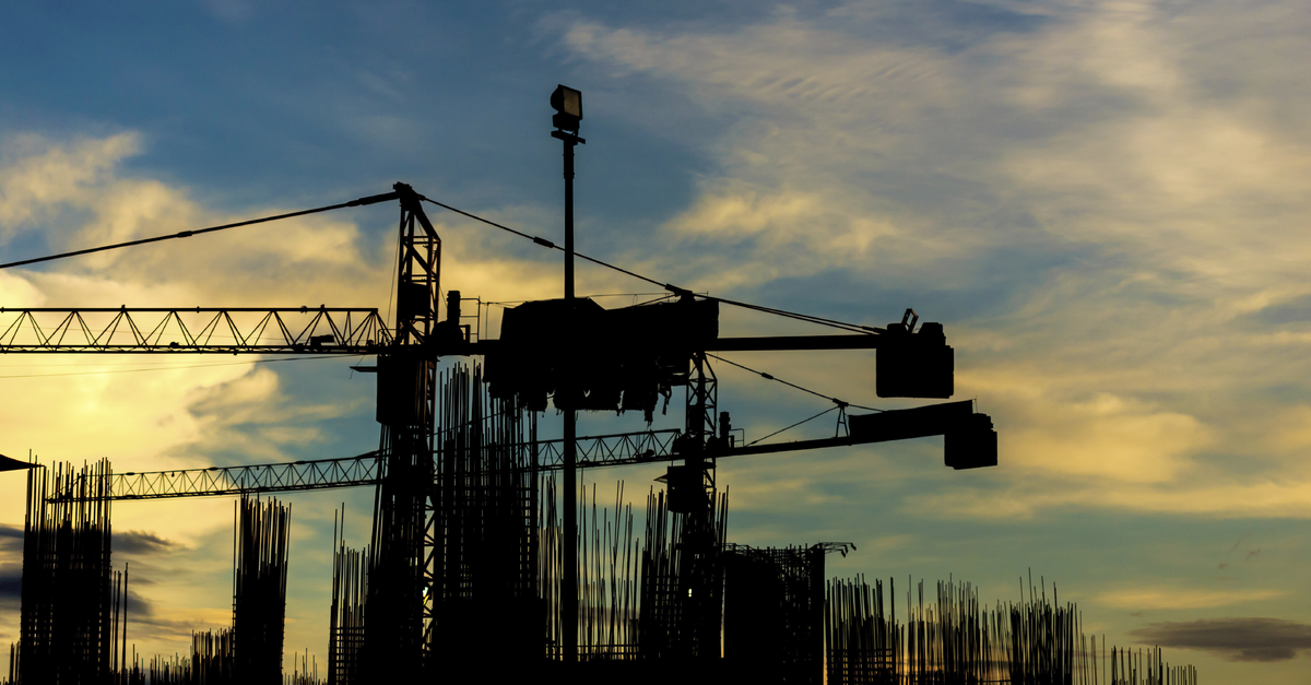 Construction site with cranes on silhouette background